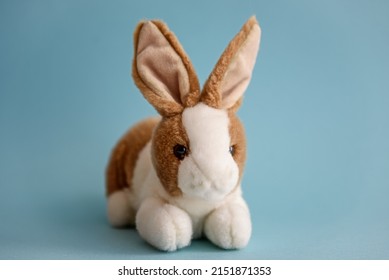 Soft Toy Rabbit On A Blue Background.