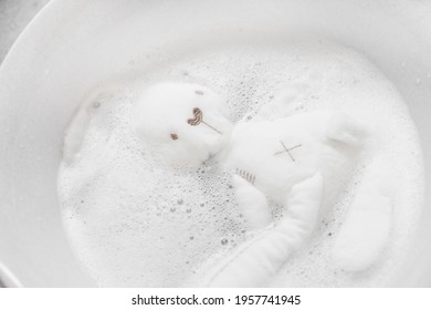 Soft toy white rabbit soaked in foam. Washing of children's toys. Hygiene at home.