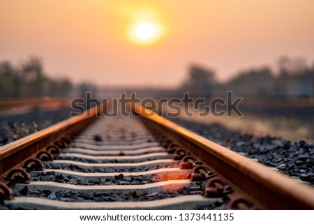 Soft track railway train on morning for transportation of travel in summer time, sunny of sun rise on morning on orange and yellow sky is beauty background