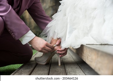 soft vintage tone image of groom assisting bride putting on her shoes