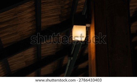 A soft, warm light emanates from a square-shaped lantern
