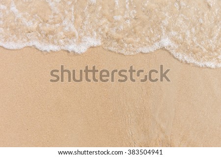 Soft wave of the sea on the sandy beach with white clean foam. Copy space
