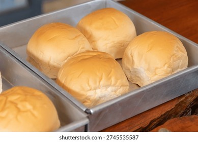 A soft white bread roll in baking tray with warm light and cozy mood