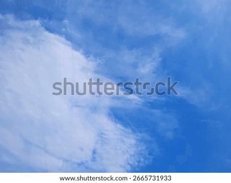Soft white clouds floating against a deep blue sky, ideal for aesthetics backgrounds, weather imagery, and peaceful nature scenes