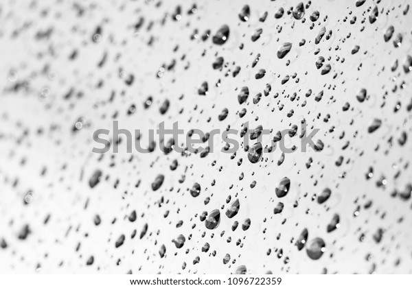 Soft\
white gray raining and water drop on glass or mirror ground. It\
circle or oval background concept. This will see bekeh white\
reflect of rain drops to make it look\
beautiful.