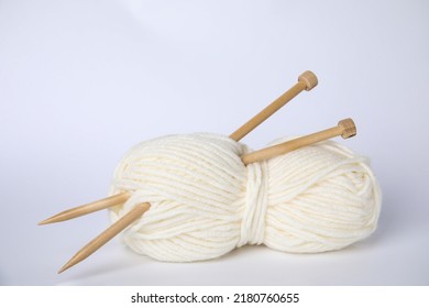 Soft Woolen Yarn And Knitting Needles On White Background