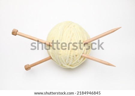 Soft yarn with knitting needles on white background