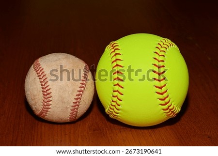 Softball and baseball on a table