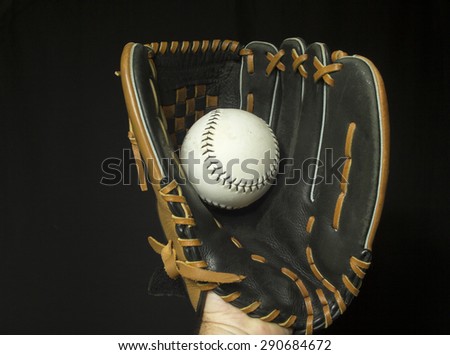 Softball mitt with white softball in webbing.