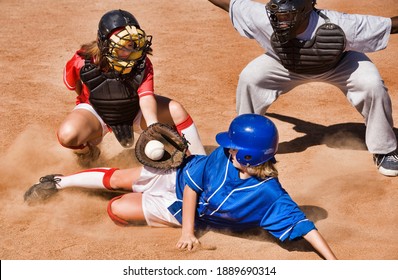 Softball Player Sliding Into Home Plate While Umpire Rules Safe