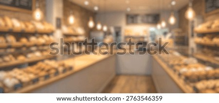 A soft-focus image capturing the warm and inviting ambiance of a contemporary bakery, showcasing shelves filled with various baked products and glowing lights.
