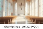 A softly blurred image of a bright, modern church with large windows and a crucifix on a white wall, sunlit pews creating a serene scene