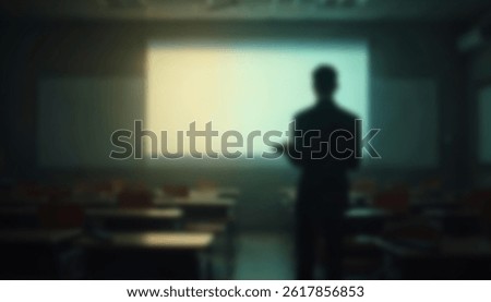 A softly blurred image of a man standing alone in an empty classroom facing a projection screen