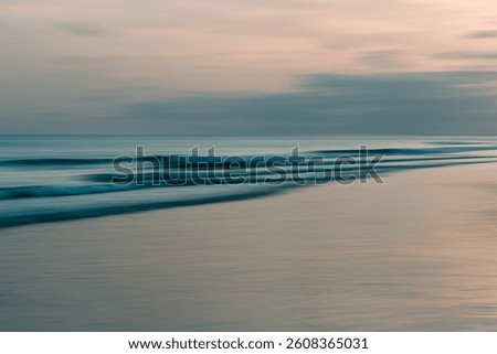 Softly blurred waves rolling onto the shore at twilight.
