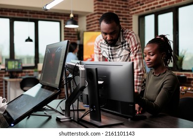 Software company employees brainstorming design ideas while sitting in office workspace. Creative agency production department workers trying to solve development issues of 3D project.