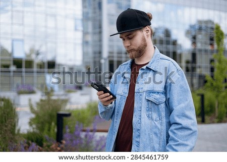 Software developer checking a smartphone during a busy workday. Mobile communication, technology, productivity and modern tech industry lifestyle concept.