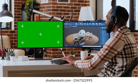 Software developer creates a gear prototype on dual monitors next to chroma key display, home office remote work. Expert does 3D modeling for innovation in the industrial design industry. Camera B. - Powered by Shutterstock