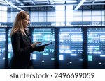 Software developer in data center implementing backup solutions to protect against data loss using laptop, ensuring efficient recovery processes. Woman in server room resolving technical issues