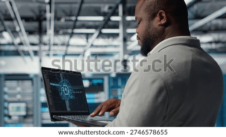 Software developer in data center uses AI technology on laptop to optimize storage volumes. IT expert in server hub facility using artificial intelligence to ensure seamless operations, camera B