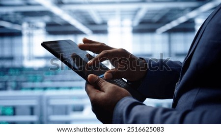 Software developer does yearly checkup using tablet to prolong data center electronics life span. Close up shot of worker in server room monitoring server infrastructure using digital device, camera B