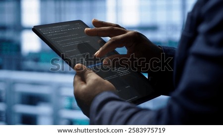 Software developer does yearly checkup using tablet to prolong data center electronics life span. Close up shot of worker in server room monitoring server infrastructure using digital device, camera A