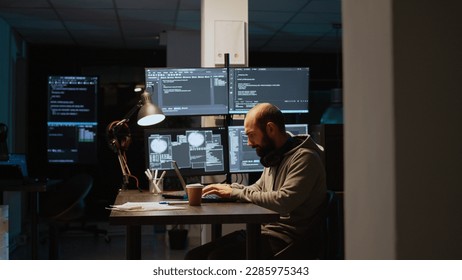 Software developer typing source code on laptop and multiple monitors, using programming language to create firewall security server. Male coder developing database cloud computing.