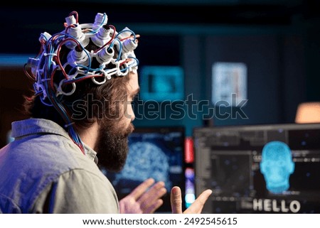 Software developer using EEG headset device translating thoughts into PC commands using brainwave signals. IT professional controlling computer functions using mind, helped by technology, close up