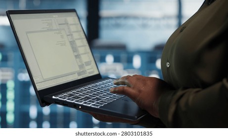 Software developer works in a data center to optimize network infrastructure and resolve equipment malfunctions.