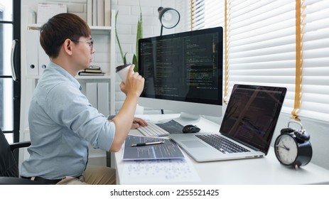 Software development concept, Male programmer checking website programming and drinking coffee.