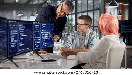 Software Engineer Coding On Computer While Collaborating With Diverse Team.