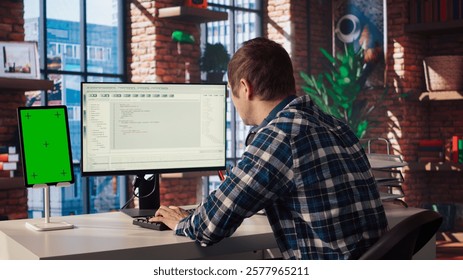 Software engineer at computer coding, creating software using isolated screen tablet. IT specialist in home office working with code editor, building applications using PC and mockup device, camera A