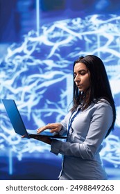 Software engineer solving tasks on laptop, running artificial intelligence programming scripts. Woman in modern lab using notebook to write lines of code for AI applications development
