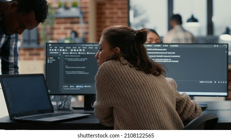 Software programer putting laptop with source code on colleague coder desk asking for opinion about database. Developer writing algorithm interrupted by coworker wanting help with fixing errors. - Shutterstock ID 2108122565