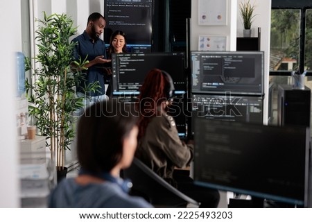Software programmers discussing about algorithms on big screen and laptop, analyzing html code language. Team of system engineers looking at database on terminal window, server interface.