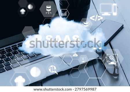 Software as a Service concept displayed on a laptop next to a cup and a phone