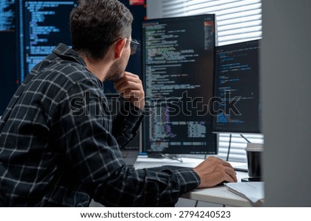 Software Specialist Analyzing System Design.Programmer studies diagrams and code, optimizing application architecture, network performance, database queries, debugging and implementation strategy for enterprise solutions.