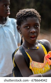 SOGA, GUINEA BISSAU - MAY 5, 2017: Unidentified local little girl in earing opens her mouth in a village of the Soga island. People in G.-Bissau still suffer of poverty