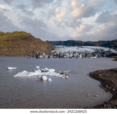 Soheimajokull picturesque glacier in southern Iceland. The tongue of this glacier slides from the volcano Katla. Beautiful glacial lake lagoon with blocks of ice and surrounding mountains.