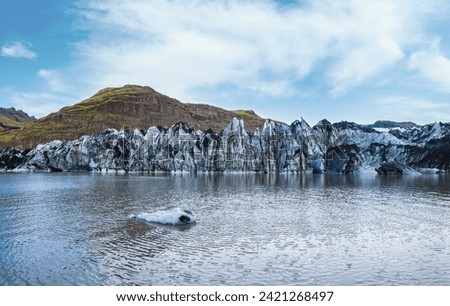 Soheimajokull picturesque glacier in southern Iceland. The tongue of this glacier slides from the volcano Katla. Beautiful glacial lake lagoon with blocks of ice and surrounding mountains.