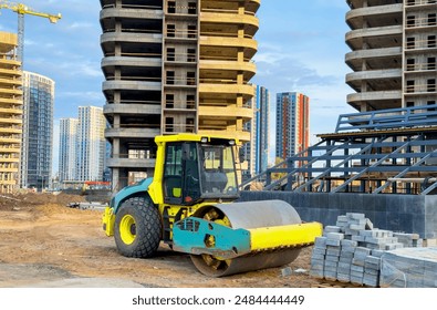 Soil Compactor for leveling ground for foundation and on road construction. Road compaction equipment at construction site. Vibration single-cylinder road roller on sunset. Building construction.