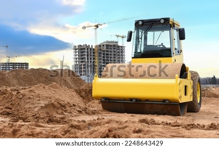 Soil Compactor for leveling ground for foundation and on road construction. Road compaction equipment at construction site. Vibration single-cylinder road roller on sunset. Building construction.