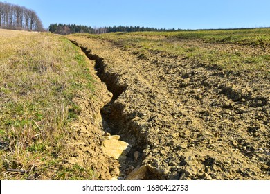 Soil Erosion Erosive Groove In Field Road, Damaged Earth In Farmer Land.