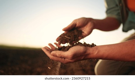 soil in the hands of the farmer. agriculture. close-up of farmers hands holding sun black soil in their hands, fertile land. garden field ground fertile concept. worker holding soil plowed field