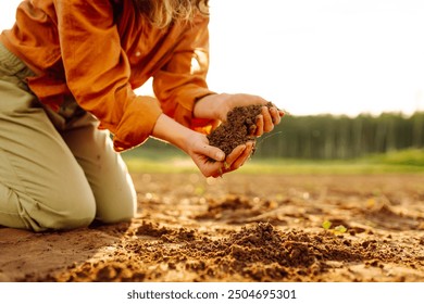 Soil is land in the hands of the farmer. Land plot close-up of hands of farmer mud peat. Garden nature. Ecology of fertile soil. The farmer works in the field. Environment in countryside.