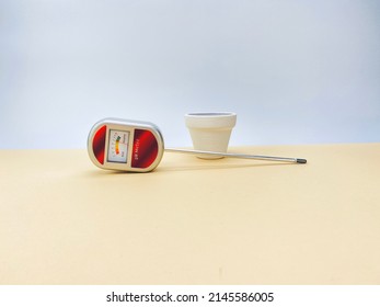 Soil PH Test Tool And White Vase On A Beige Table Against White Wall