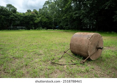 Soil roller laying of the field. Old rusty metal lawn roller on sports ground - Powered by Shutterstock