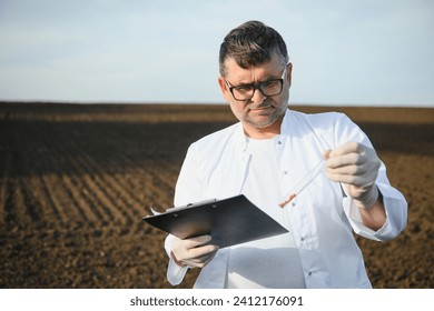 Soil Sampling. Agronomist taking sample with soil probe sampler. Environmental protection, organic soil certification, research.