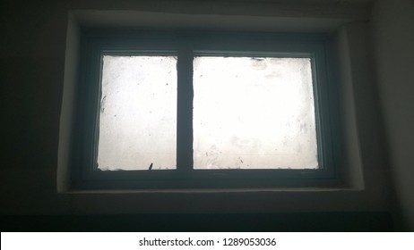 Soiled And Defocused Image For Background. Texture, Wallpaper Of An Old Dirty Green Window Showing Gray Sky Of A Winter Or Autumn Day.