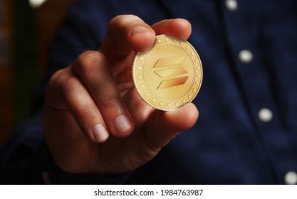 Solana altcoin cryptocurrency symbol golden coin in hand abstract concept.