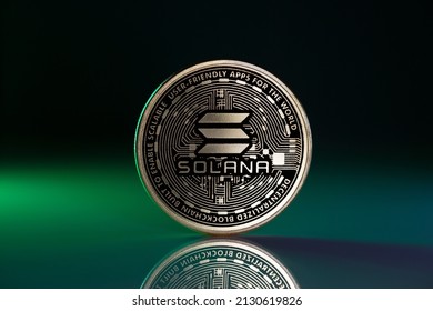 Solana SOL Physical Coin Placed on Reflective Surface and lit with green light - Shutterstock ID 2130619826